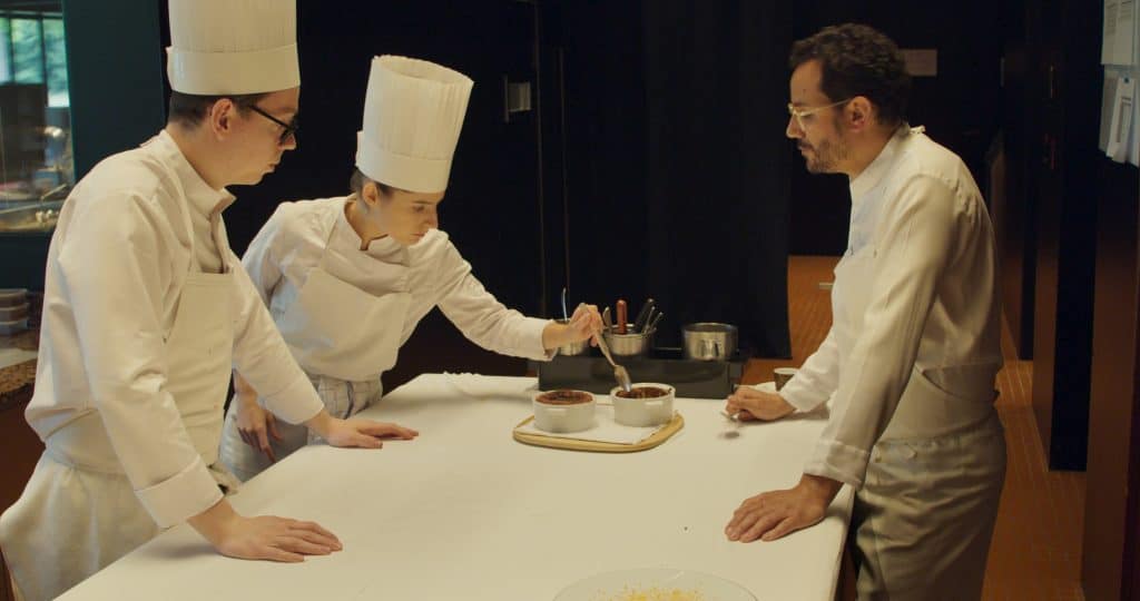 A group of chefs standing around a table.