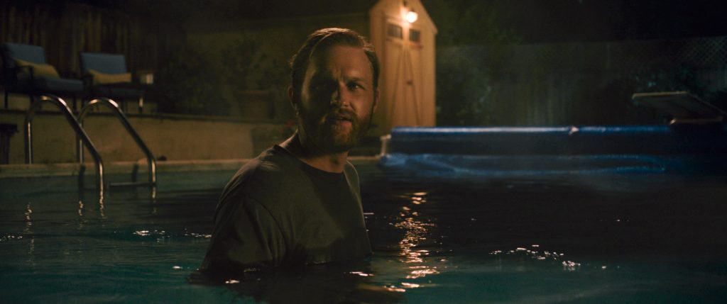 A man standing in a pool at night.