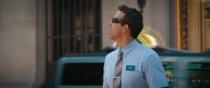 A man in a blue shirt and tie is walking down the street.