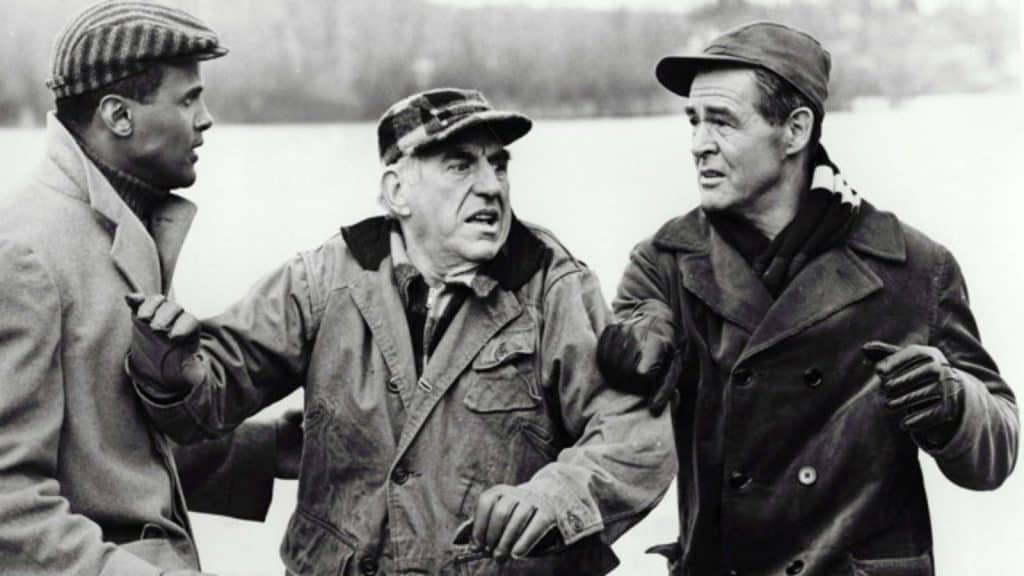 Three men in jackets and hats talking to each other.