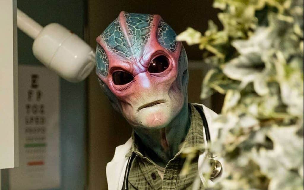 A man in a mask is standing in front of a plant.