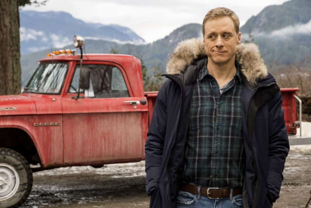 A man standing in front of a red truck.