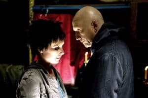 A man and woman standing next to each other in a dark room.