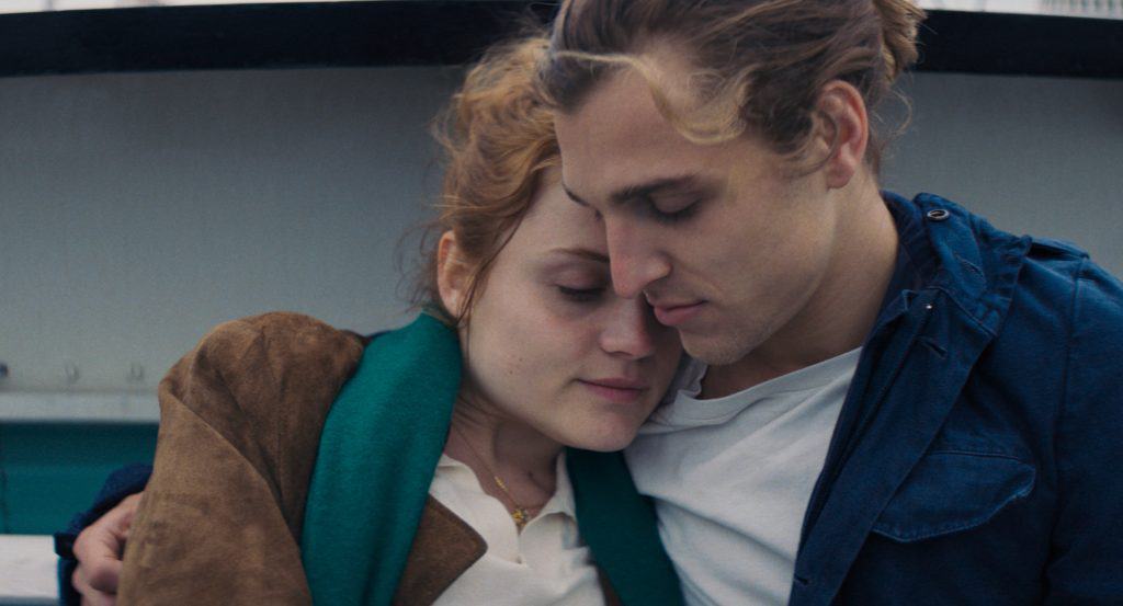 A man and woman hugging each other on a boat.