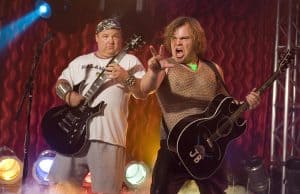Two men playing guitars on stage.