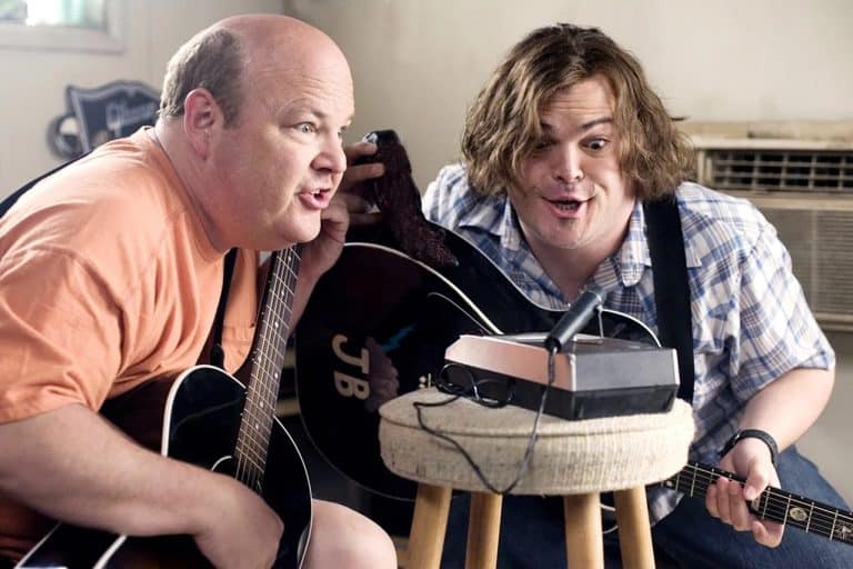 ‘Tenacious D In The Pick of Destiny’ Blu-Ray Review – A Hilarious Gift For Fans Of The Band Two men sitting on a stool with guitars.