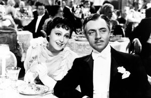 A black and white photo of a man and woman sitting at a table.