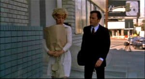 A man and woman walking down a sidewalk.