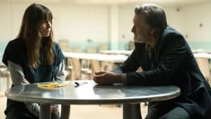 A man and a woman sitting at a table in a prison.