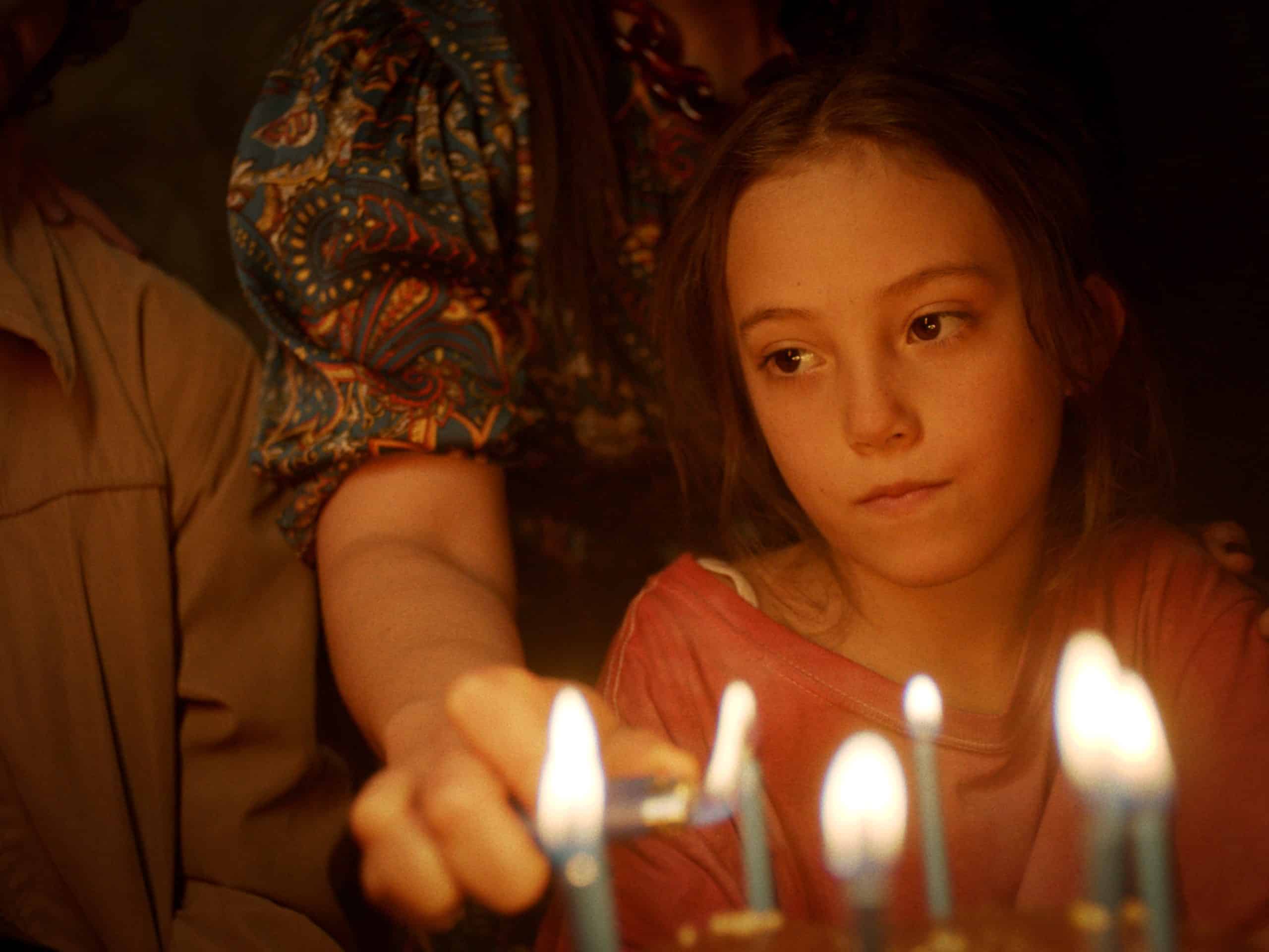 A girl blowing out candles on a cake.