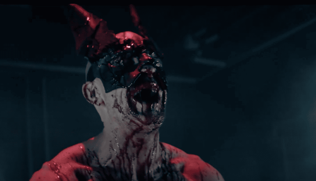 A demon with horns and blood on his face.