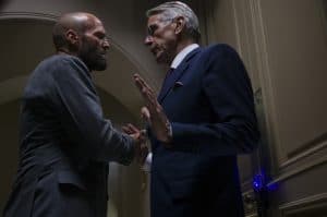 ‘The Beekeeper’ 4K UHD Blu-Ray Review – A Gleeful Onslaught Of Bone-Crunching Violence Two men in suits shaking hands in a hallway.
