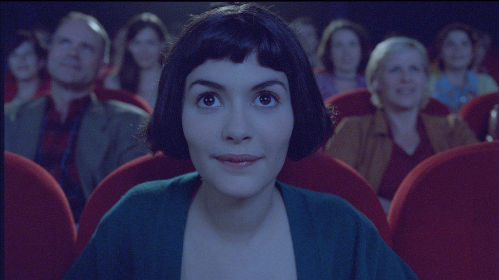 A woman in a theater looking at the audience.