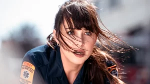 A woman in uniform with her hair blowing in the wind.