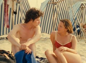 Eric Rohmer’s Tales Of The Four Seasons Criterion Collection Blu-Ray Review – A Moving & Timeless Quartet A man and a woman sitting on the beach.