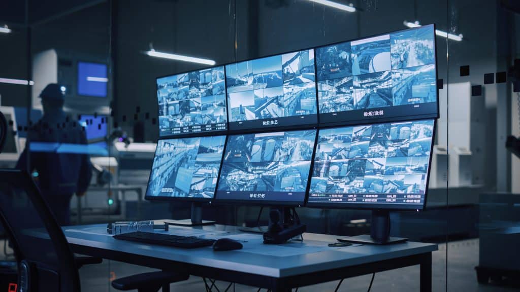 Cctv monitors on a desk in a factory.