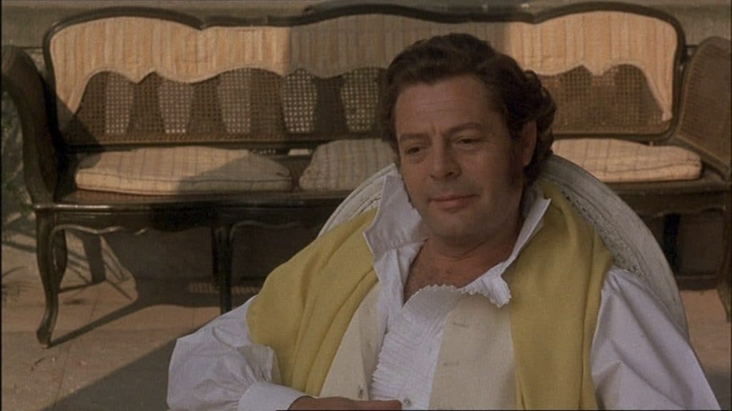 A man sitting in a chair with a yellow scarf.