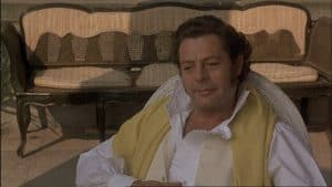 A man sitting in a chair with a yellow scarf.
