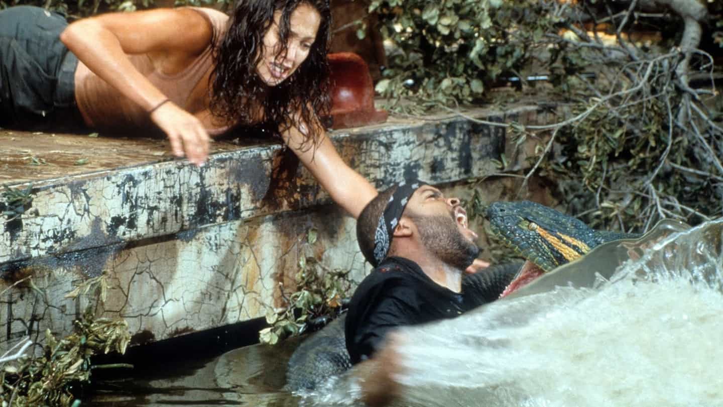 A man and woman laying on a board in the water.