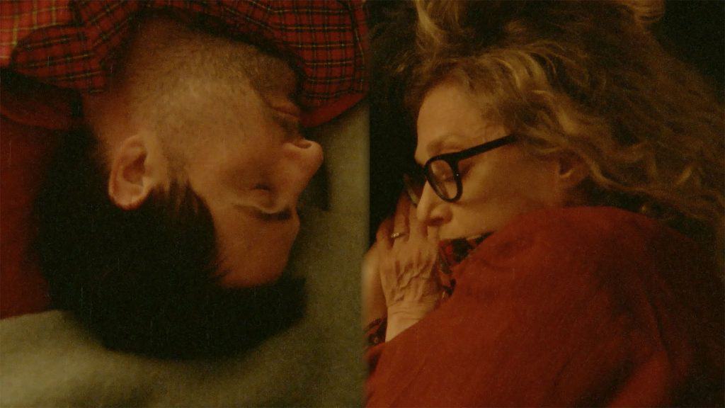 A man and a woman sleeping in a bed.