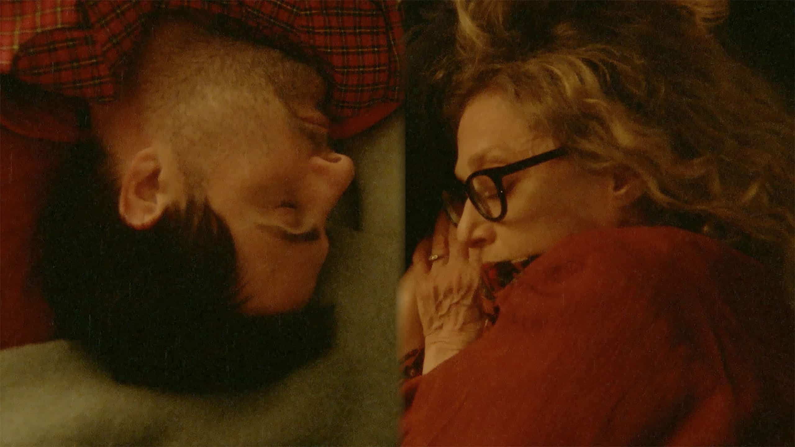 A man and a woman sleeping in a bed.
