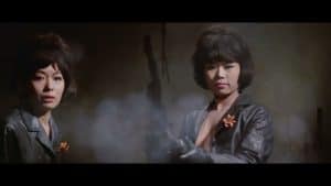 Two asian women in leather jackets holding guns.