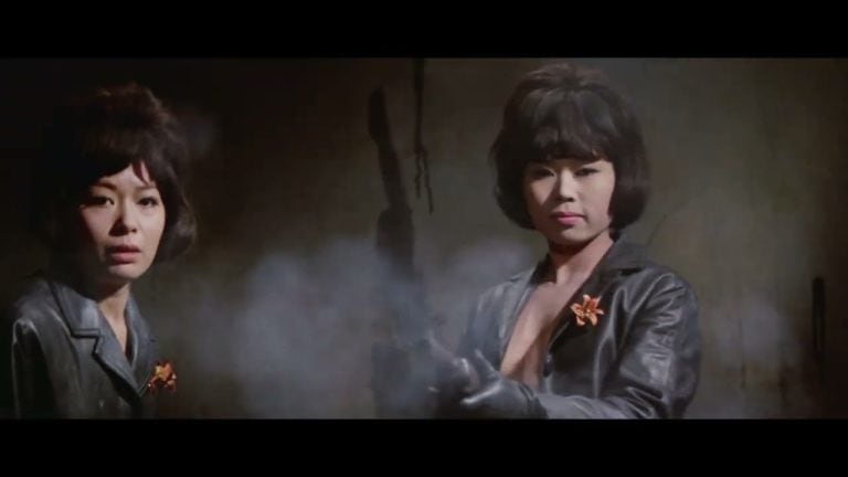 Two asian women in leather jackets holding guns.