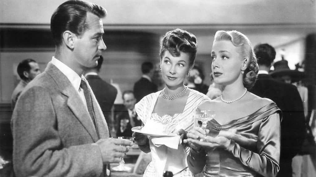 A woman is talking to a man at a party.