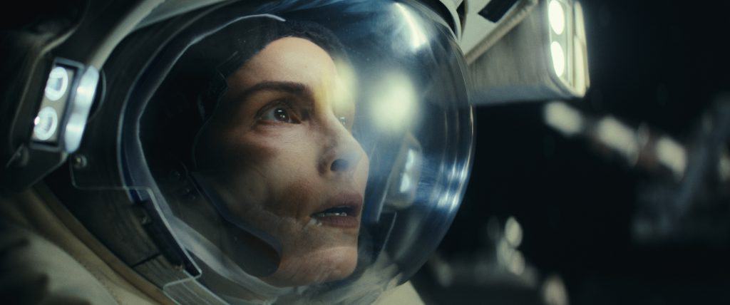 A woman in a space suit looking at the camera.