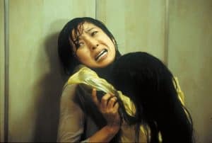 A woman is hugging another woman in a room.