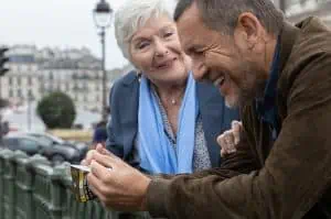 A man and woman looking at a cell phone in a city.