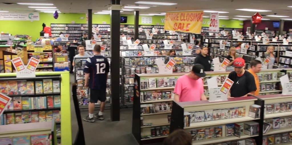 A group of people are shopping in a video store.