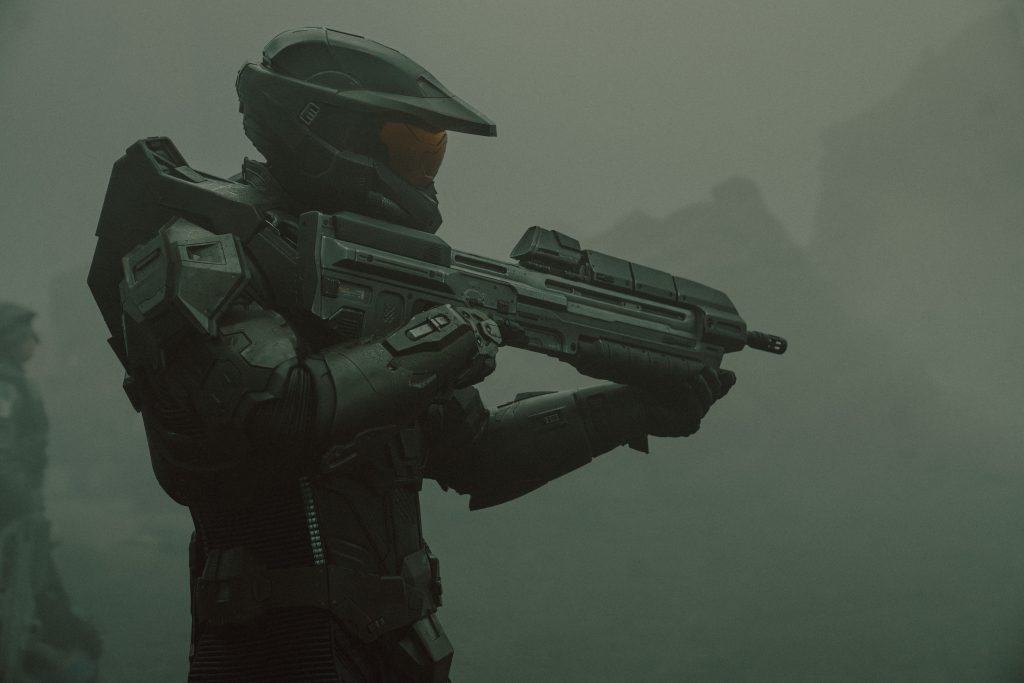 A person in a garment holding a gun.