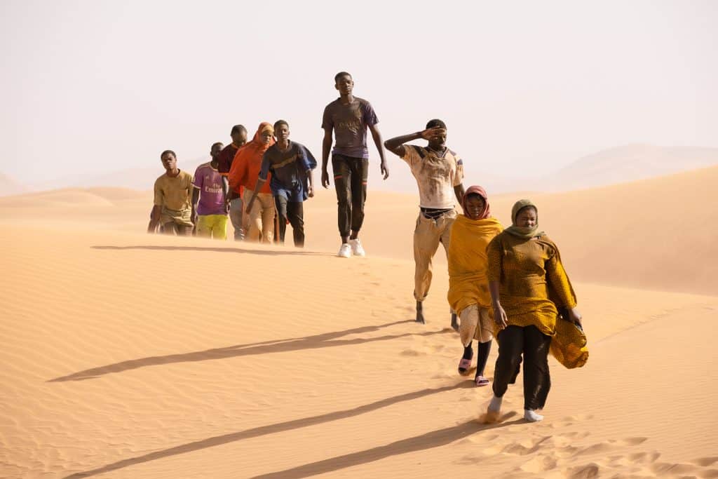 A group of people walking through the desert.