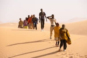 ‘Io Capitano’ Blu-Ray Review – A Heart-Wrenching Look At The Struggle To Make A Better Life A group of people walking through the desert.