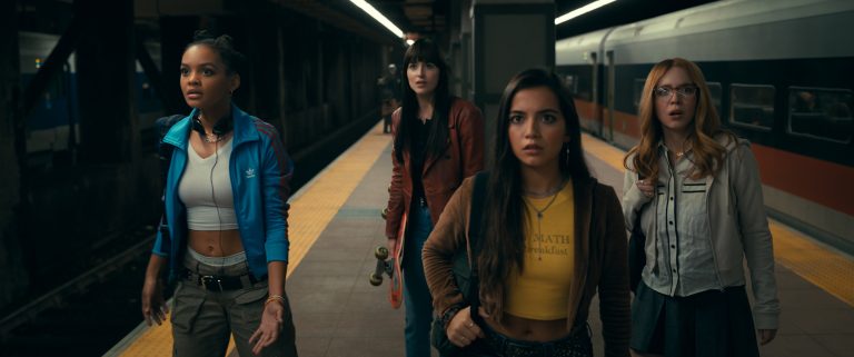 A group of girls standing on a train platform.