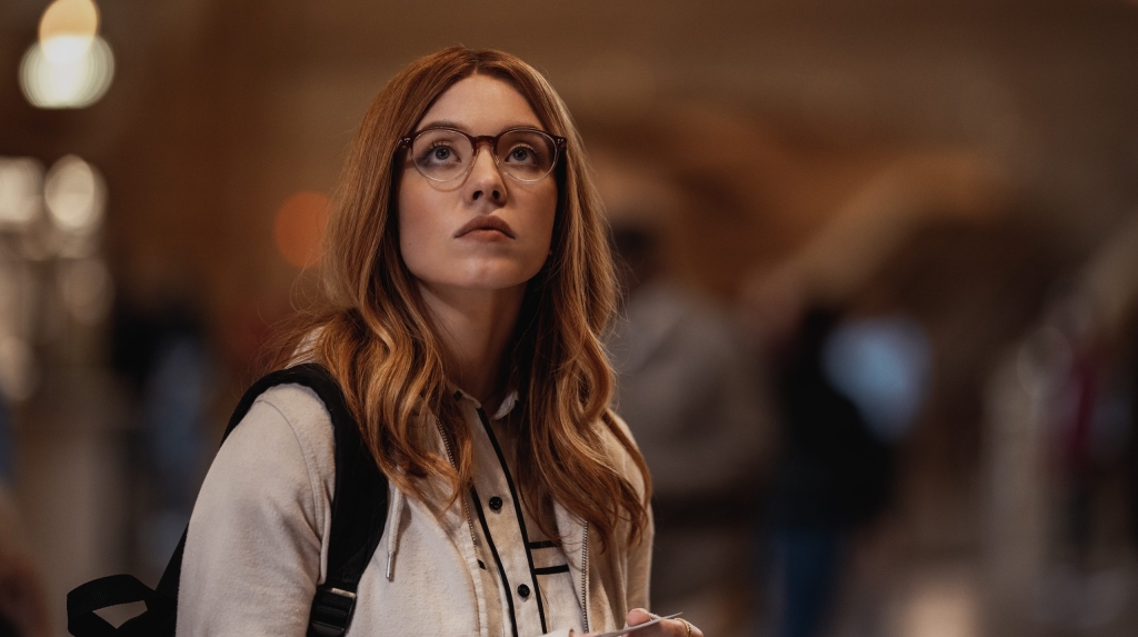 A woman in glasses standing in a crowd.