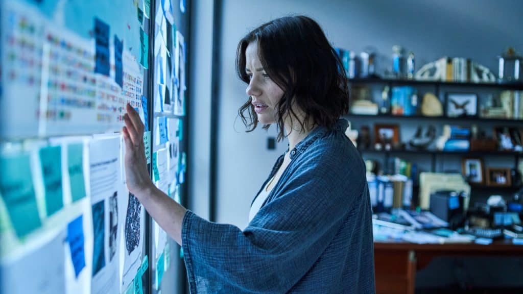 A woman looking at a wall of papers.