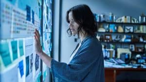 A woman looking at a wall of papers.