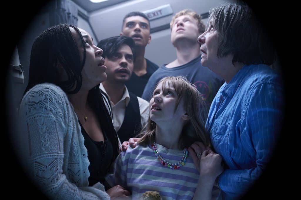 A group of people in an airplane looking at each other.