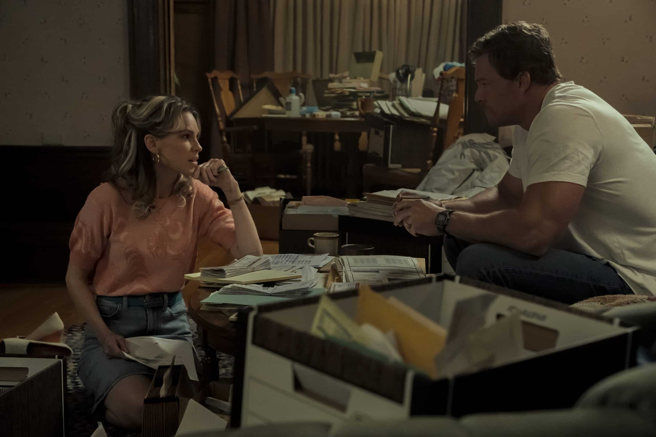 A man and woman sitting on a couch in a living room.