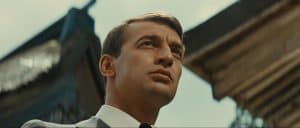 A man in a suit and tie is staring off into the distance.