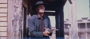 A man in a cowboy hat holding a gun.