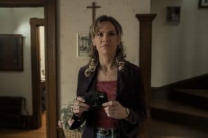 A woman standing in a room holding a camera.