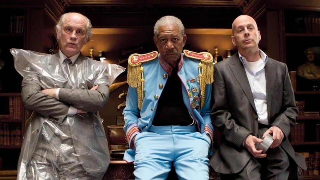 Three men in suits sitting on a couch.