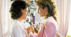 Two women in pink suits standing next to each other.