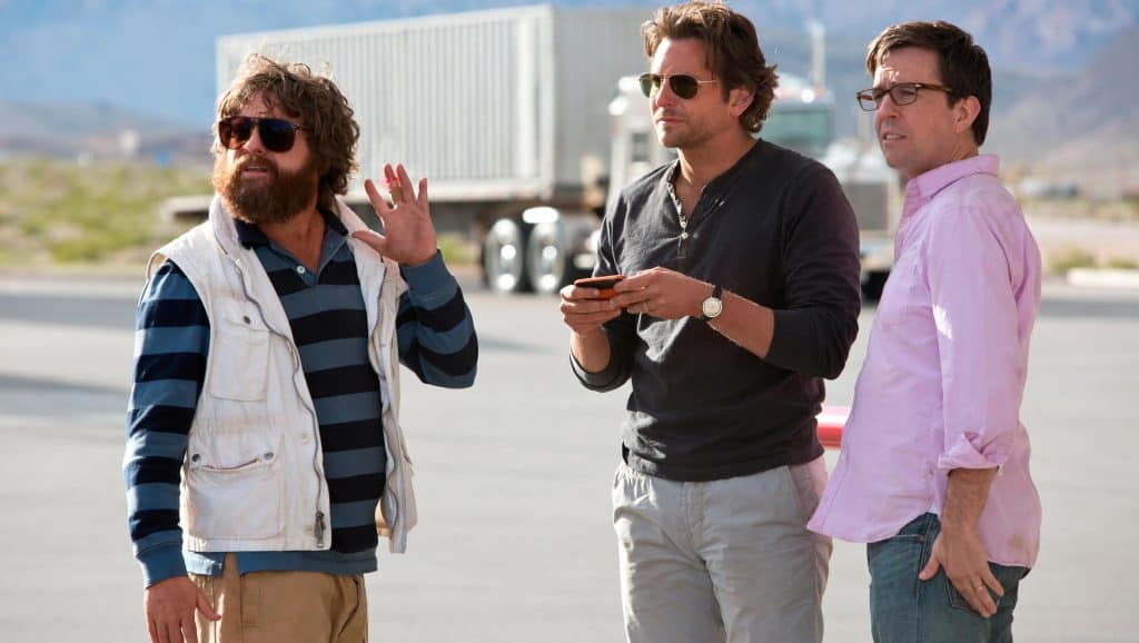 Three men are standing in front of a truck.