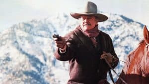 A man in a cowboy hat holding a gun.