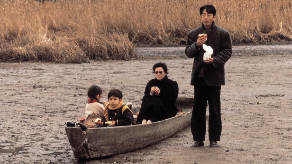 A man in a canoe with his family.