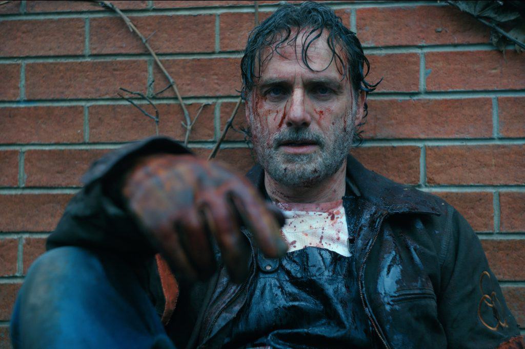 A man with blood on his face and bloody hands.